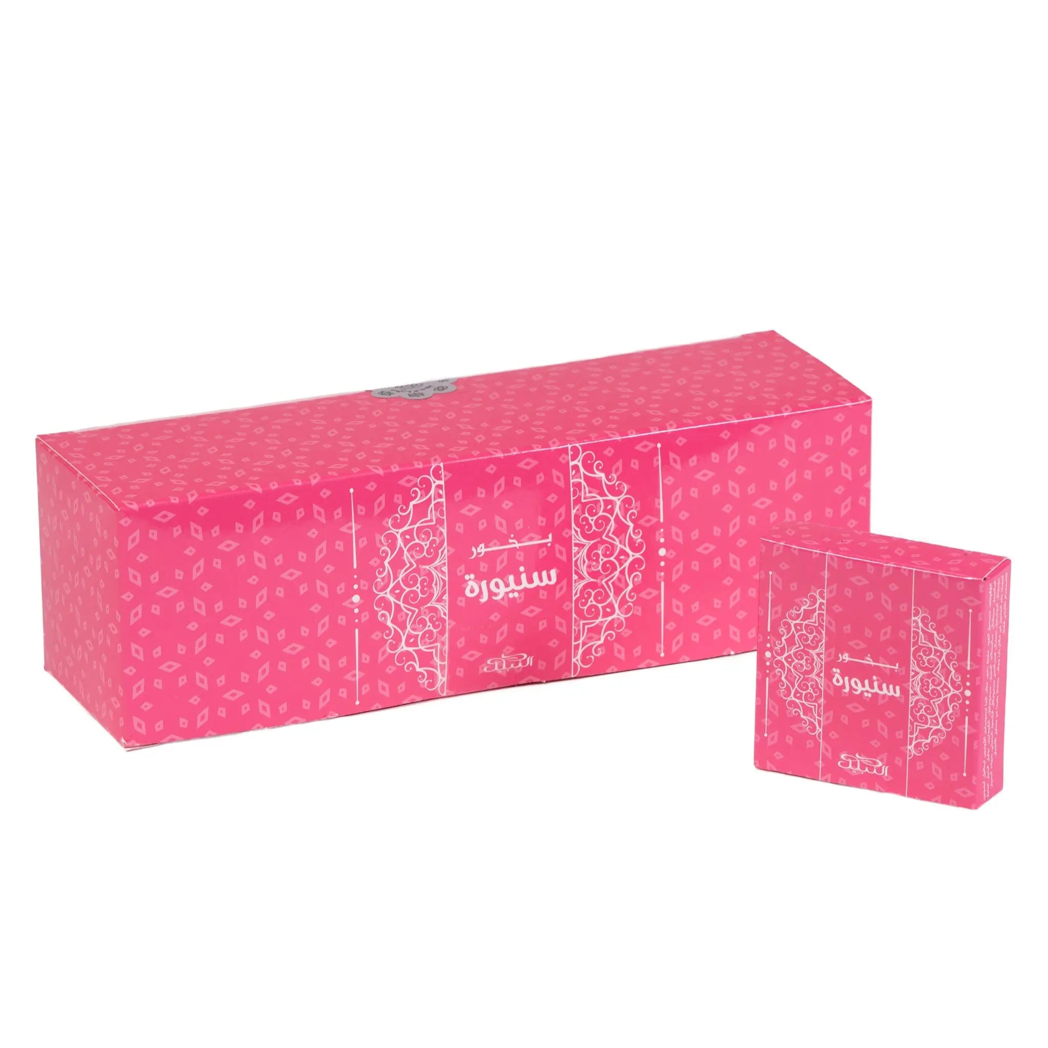 The image displays a vibrant pink packaging set for "Bakhoor Senora" by Nabeel Perfumes. The set includes a long rectangular box and a smaller square box, both featuring an intricate white arabesque pattern over the bright pink background. The name "Senora" is written in white Arabic calligraphy in the center of each box, with smaller English lettering beneath it. The design is elegant and suggests a feminine and possibly floral-scented product within.