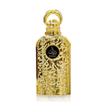 The image shows a luxurious perfume bottle. The bottle has a golden color with intricate arabesque patterns carved into its metal exterior, giving it a very ornate and decorative appearance. The cap of the bottle is also golden and has a circular handle, likely for aesthetic purposes. In the center of the bottle, there is a black label with the word "BAYAAN" written in stylized white Arabic script. The background is plain, highlighting the detailed craftsmanship and opulent design of the perfume bottle.