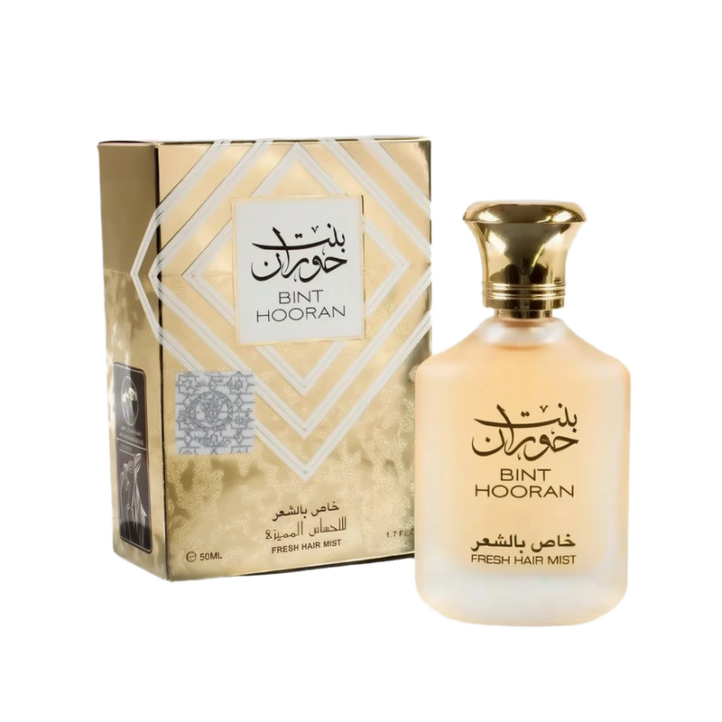 The image shows a fragrance product consisting of a bottle and its corresponding box. It features the label "BINT HOORAN" in both English and Arabic calligraphy. Below the name, the text "FRESH HAIR MIST." The box has a gold metallic finish with geometric white and gold patterns framing a white label with the name "BINT HOORAN." Additional details on the box label include "FRESH HAIR MIST" and the volume "50ML / 1.7 FL.OZ."