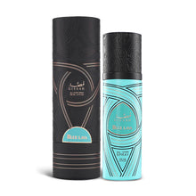 A cylindrical turquoise bottle of Gissah Blue Lava all-over spray with a capacity of 100 mL (3.4 FL OZ), displayed next to its matching cylindrical black packaging. The bottle features intricate black patterns and a black cap with similar detailed designs. The Gissah brand name and "Blue Lava" are prominently displayed in gold lettering on the front of the bottle. The packaging features the same elegant black patterns and turquoise accents.