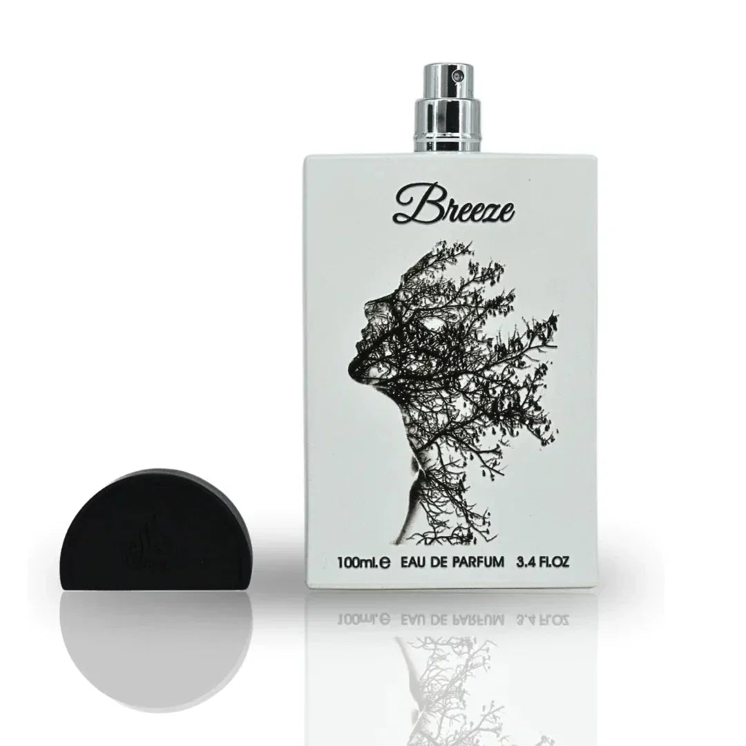 The image displays a perfume bottle named "Breeze" by Lattafa. The bottle has a flat, flask-like shape with a silver spray nozzle and a black cap beside it. It features a creative black print of a woman's profile, depicted with tree branches against the w