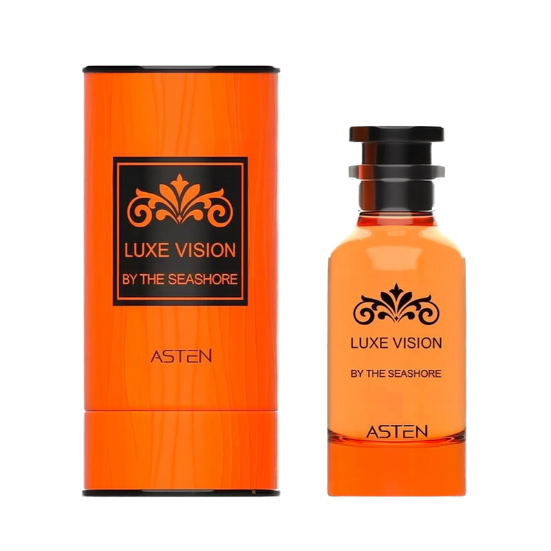 A bright orange cylindrical perfume container with a black-embossed decorative flourish and the text Luxe Vision By The Seashore printed on the front, displayed next to a matching orange-hued glass bottle topped with a sleek black cap and adorned with the same black motif and brand name Asten.