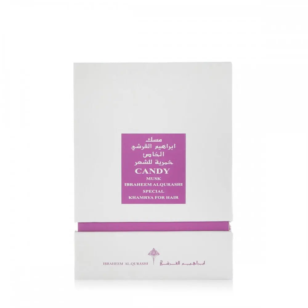 The image shows a white packaging box for a fragrance product, with a purple label in the center. The label includes English and Arabic text, reading "CANDY MUSK IBRAHEEM AL QURASHI SPECIAL KHAMRIYA FOR HAIR." A purple band accents the lower portion of the box.
