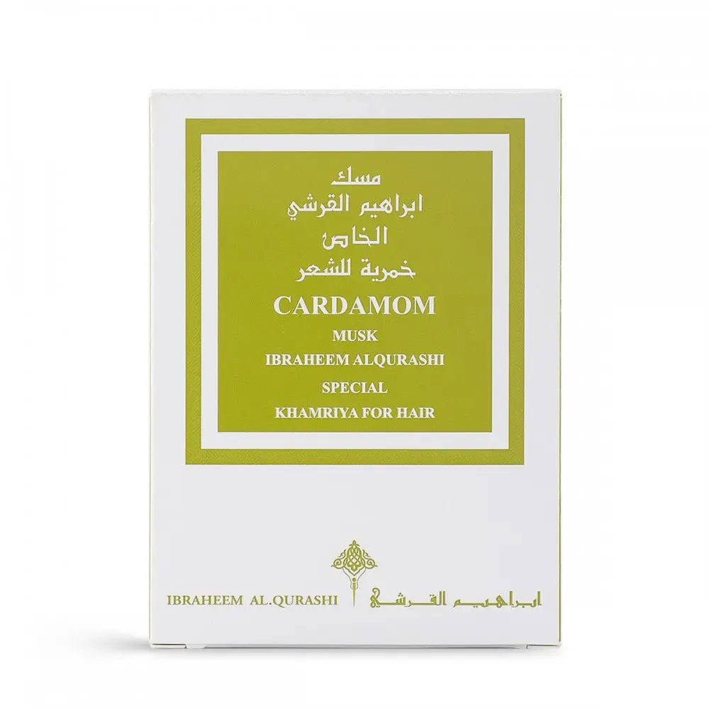  The image shows a white packaging box with a green label for a fragrance product. The label has both English and Arabic text, reading "CARDAMOM MUSK IBRAHEEM AL.QURASHI SPECIAL KHAMRIYA FOR HAIR." The design of the box is simple and elegant, with the brand's logo at the bottom. The color scheme and product name suggest a hair fragrance with cardamom scent notes.