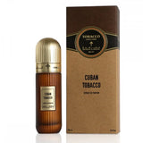 The image presents a bottle of "Cuban Tobacco" Extrait de Parfum next to its packaging. The bottle features a brown gradient design with a gold-colored cap and a label that specifies "Cuban Tobacco" in white text on a dark background. It notes the volume as 100 ml or 3.4 fl oz. The accompanying box has a brown craft paper texture with a central label that repeats the name of the fragrance and the brand "Ibraheem Al Qurashi" within an ornate border.