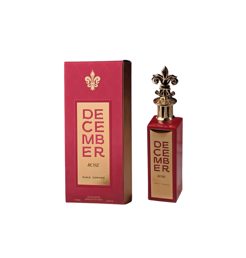 A tall, rectangular red perfume bottle with a gold fleur-de-lis–shaped cap and a vertical gold label reading “December Rose” by Paris Corner, shown next to its matching red box featuring the same gold accents and branding.