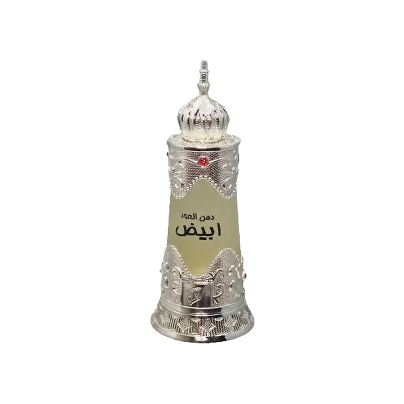 The image depicts a traditional Arabic-style perfume bottle. The bottle is cylindrical with a tapered base and features intricate silver metallic filigree work around the top and bottom, giving it an ornate and luxurious look. The central portion of the bottle is a frosted glass with a label that includes Arabic script, likely denoting the name of the perfume. At the top of the bottle sits a decorative silver dome-shaped cap with a pointed finial, adorned with a red gem at its center. 