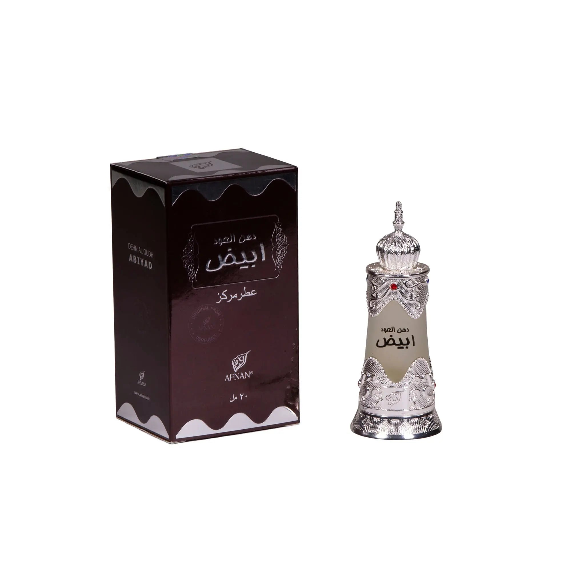 The image shows a set of Arabic perfume products, including a box and a bottle. The box is dark brown with a glossy finish and features intricate white and gold detailing, including Arabic calligraphy that reads "العود" (Al Oud), which suggests that the perfume is of the Oud fragrance variety. The brand name "AFNAN" is also visible on the box. Beside the box stands an ornate perfume bottle, similar to the one described earlier, with intricate silver filigree work and a frosted glass center. 