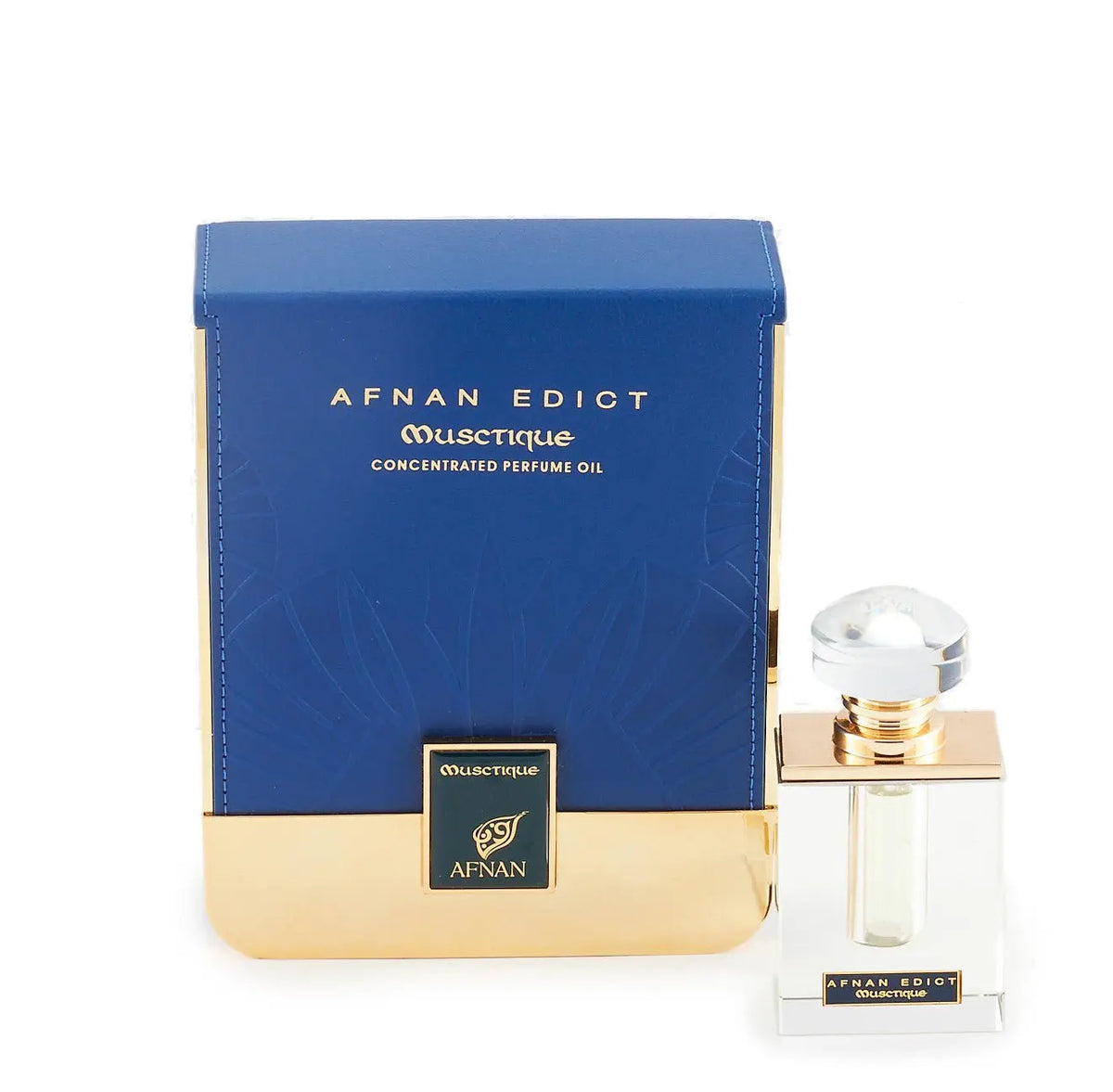 The image shows a perfume product with its packaging. The perfume bottle is clear with a square base and features a golden band around the neck, topped with a large, round, clear cap. The front label is minimalistic, with the name "AFNAN EDICT OUSCTIQUE" in a simple font. Next to the bottle is its box, which is predominantly navy blue with a textured pattern and a broad golden base.  The combination of navy blue and gold suggests a luxurious and sophisticated product.