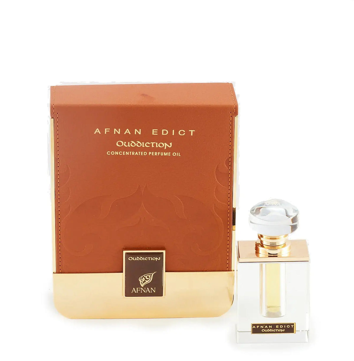The image shows a perfume product consisting of a rectangular glass bottle and its packaging. The bottle, placed to the right, has a clear liquid with a golden neck and a large, transparent, faceted cap. On its front, there's a label with "AFNAN EDICT Ouddiction" in black letters on a gold background. To the left is the box, in a gradient of brown to gold with a subtle paisley design, and it reads "AFNAN EDICT Ouddiction CONCENTRATED PERFUME OIL" in gold embossed letters. 
