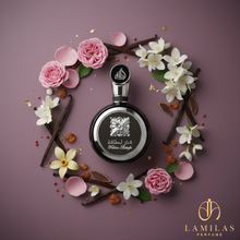 Black Fakhar Lattafa perfume bottle surrounded by a wreath of pink roses, white florals, vanilla pods, and amber resins.