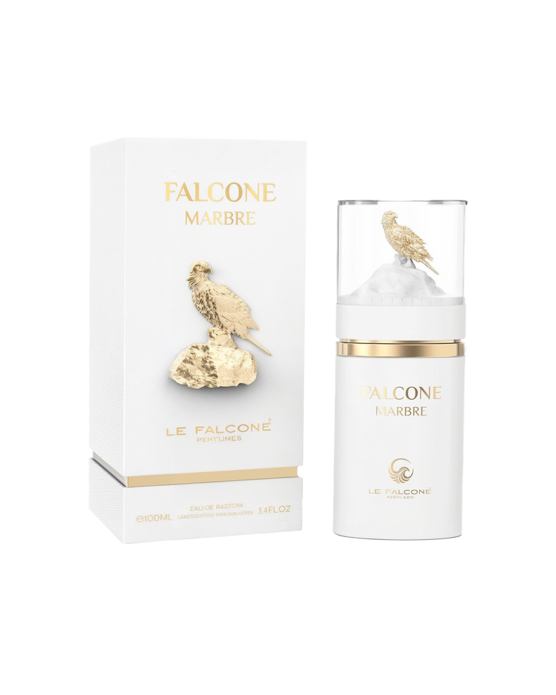 A white rectangular perfume box labeled ‘Falcone Marbre’ by Le Falcone stands beside a matching cylindrical white bottle with a clear cap showcasing a gold falcon perched on a white rock.
