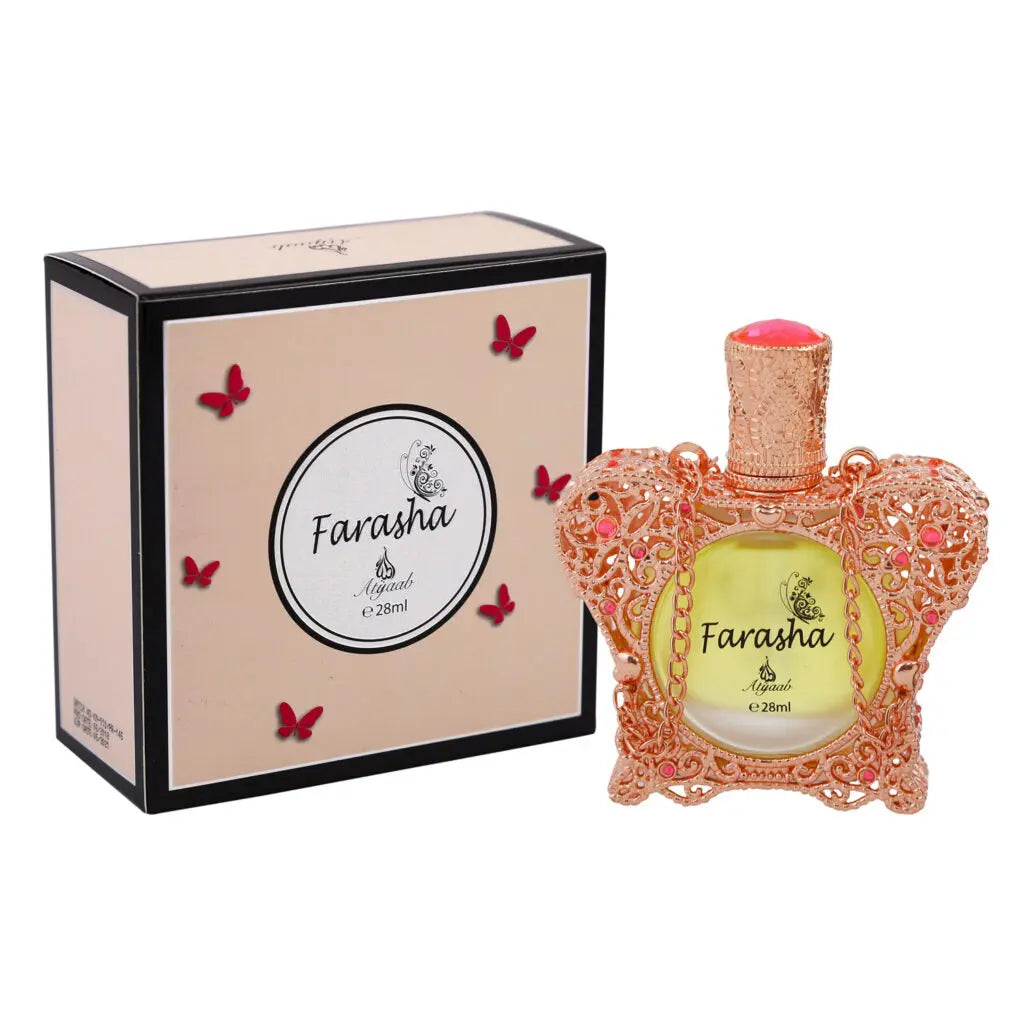 The image shows a perfume product with a uniquely designed bottle and packaging. The bottle is ornate with a delicate pinkish-orange filigree design and a peach-colored top, containing a yellow-toned fragrance liquid. It has the name "Farasha" in a stylized script on the front.  Accompanying the bottle is a beige box with a simple, elegant design, featuring the same name "Farasha," small butterfly motifs in red, and the brand "Ayyashi e 28ml" indicating the fragrance volume. 