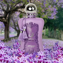 The image shows a bottle of "Fatima Velvet Love" extrait de parfum by Zimaya set against a background of a lavender field with trees. The perfume bottle is a soft lavender color with a silver spherical cap and is adorned with matching lavender tassels. It features a lavender label with ornate detailing and silver text that reads "Fatima" in both English and Arabic, along with "Velvet Love," "extrait de parfum," and the brand name "zimaya" at the bottom. 