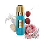 A visually striking presentation of Greek Tobacco Extrait De Parfum by Ibraheem Al-Qurashi. The vertically ribbed light blue bottle with a metallic gold dome cap is surrounded by splashes of water and key fragrance elements, including white orchid petals, pink lychee, a pale rose blossom, and creamy resin. The gold nameplate on the bottle displays 'GREEK TOBACCO' and product details in bold black text. The dynamic black background highlights the freshness and luxurious composition of the scent.