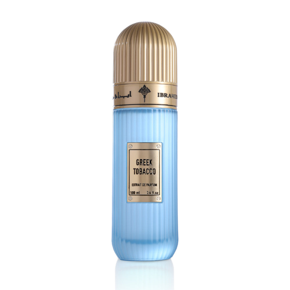 A stylish bottle of Greek Tobacco Extrait De Parfum by Ibraheem Al-Qurashi. The design features a sleek, vertically ribbed light blue bottle paired with a domed, metallic gold cap. A gold nameplate label on the front displays the fragrance name 'GREEK TOBACCO' and product details in black text. The gold band around the top is embossed with Arabic calligraphy and the Ibraheem Al-Qurashi logo.