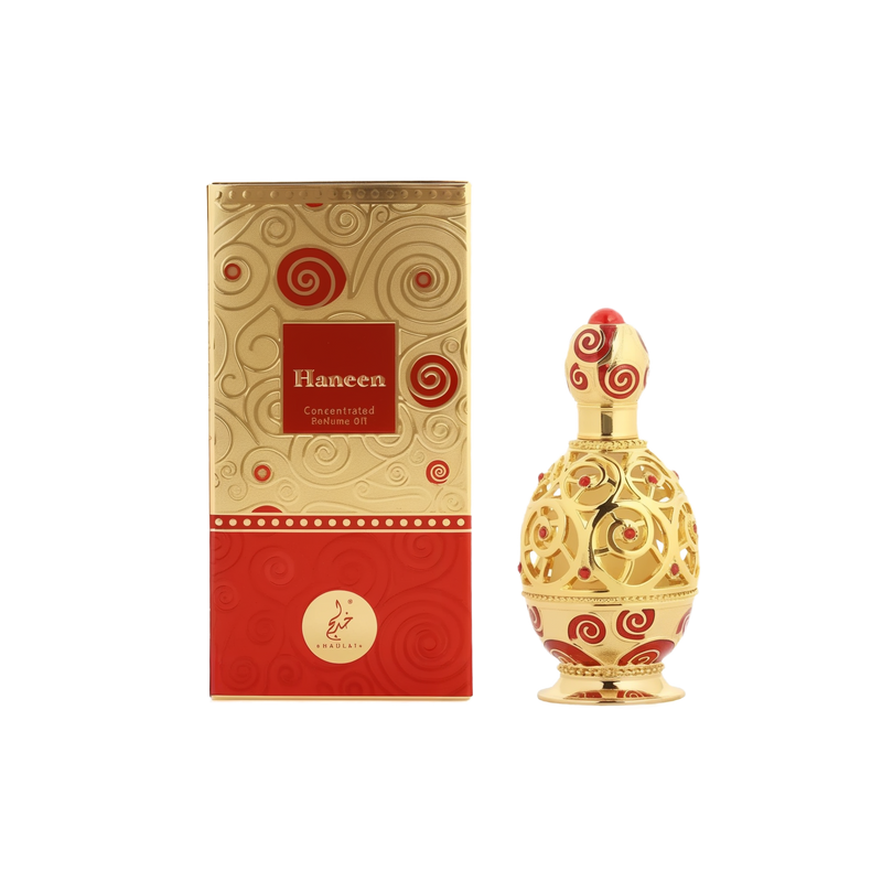 A luxurious perfume oil bottle and its matching box from Khadlaj Perfumes. The box is gold with red accents and intricate swirling patterns, featuring the brand name "Haneen" in elegant script. The bottle is gold with ornate red swirls, designed with an elaborate, rounded shape that exudes elegance and sophistication. The design elements reflect a refined and luxurious aesthetic.