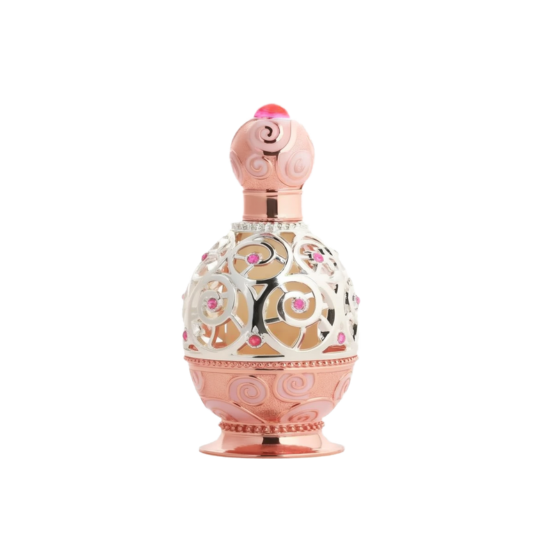 The image depicts an ornate perfume bottle on a white background. The bottle features a rose gold base and cap with intricate swirl patterns embossed on the surface. A decorative metal overlay with filigree designs encases the clear central portion of the bottle, adorned with small pink gemstone accents. The cap is topped with a pink crystal-like element, adding to the luxurious appearance of the bottle.