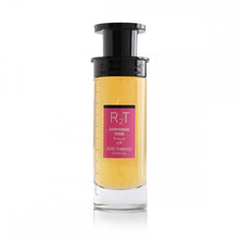 This is an image of a cylindrical clear perfume bottle with a black top and pump. The perfume has a yellow tint and features a pink label with the initials "RT" in large letters, the phrase "HAPPINESS DOSE" in smaller letters, both in English and Arabic, and "ROSE TOBACCO" underneath. The bottle is showcased against a plain white background, focusing on the simplicity and elegance of the design.
