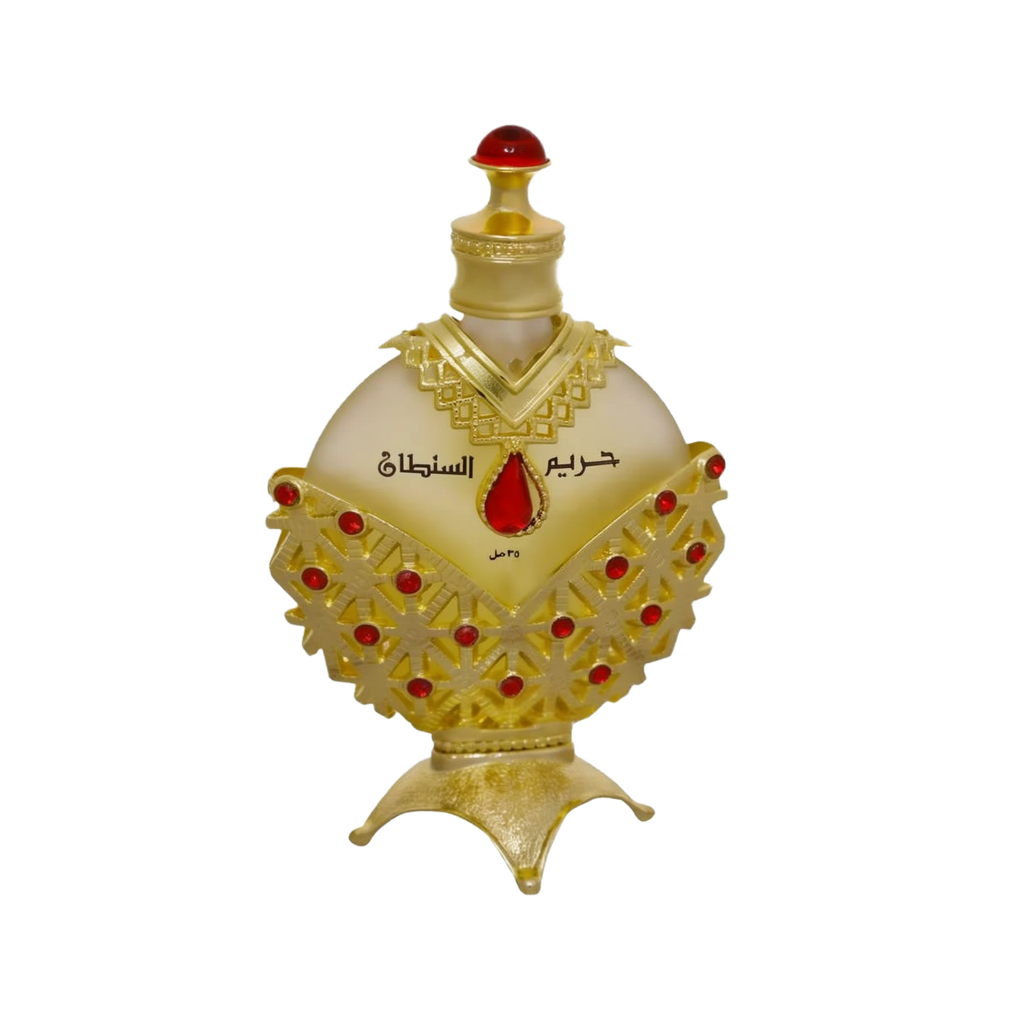 The image displays an opulent perfume bottle with a white background. The body of the bottle is a pale, translucent yellow, topped with a bright red cap resembling a gemstone. The bottle is adorned with a golden overlay featuring intricate cut-out patterns and red gemstone accents. Arabic script is prominently displayed in the center, with smaller text below.