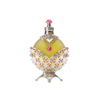 A round perfume bottle with a yellowish-green liquid, adorned with intricate silver and pink detailing, including a red teardrop-shaped gemstone at the center and a silver cap with a pink top.
