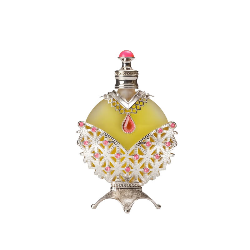 A round perfume bottle with a yellowish-green liquid, adorned with intricate silver and pink detailing, including a red teardrop-shaped gemstone at the center and a silver cap with a pink top.