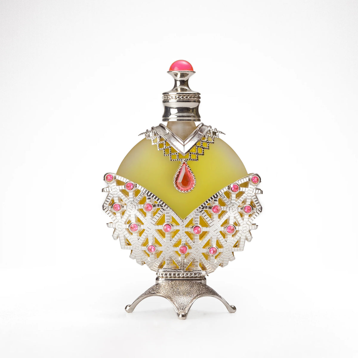 A round perfume bottle with a yellowish-green liquid, adorned with intricate silver and pink detailing, including a red teardrop-shaped gemstone at the center and a silver cap with a pink top.