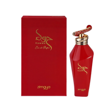 The image features a red perfume bottle alongside its box. The bottle has a glossy red finish with a gold cap, topped by a distinctive ring with a red and gold patterned design. Gold lettering on the bottle spells out the brand's name in an elegant, cursive script followed by the word "zimaya" in a smaller, standard font. The rectangular box mirrors the bottle's color scheme and includes the same branding in gold lettering. The overall presentation suggests a luxurious fragrance product.