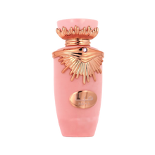 The image is a product shot of a pink bottle with metallic rose gold accents. The bottle has a distinctive shape with a flared neck and a decorative element that resembles wings around the cap, which might indicate that it is a fragrance bottle. The center of the bottle features a metallic rose gold oval-shaped plaque with an emblem or logo. The cap also has a small, circular detail that could be a gemstone, adding to the luxurious appearance of the bottle. 