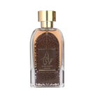 The image shows a clear glass perfume bottle with a golden cap. The perfume liquid is a dark amber color. The front of the bottle features a decorative motif resembling a dome with geometric patterns in brown and a central label with the name "HAYAATI OUD" in gold lettering and elegant Arabic calligraphy. The overall design suggests an opulent and exotic fragrance, and the bottle is set against a plain white background to emphasize its design and contents.