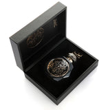 A luxurious black, octagonal perfume bottle with intricate gold embossed designs on the front, displayed inside an open black box. The bottle features a matching black and gold cap. The interior of the box is lined with black velvet, and the Gissah brand name is elegantly printed in gold on the inside lid. The presentation of the perfume in the box exudes sophistication and elegance.