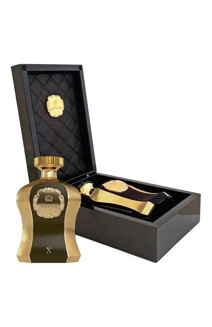 The image features a luxurious perfume presentation set. It includes a gold-colored perfume bottle with the word "HIGHNESS" and the letter "X" on its front, suggesting it may be part of a distinguished series or a special edition. Accompanying the bottle is a sophisticated black box with a quilted interior lid, within which lies a gold-colored medal or ornament that echoes the design of the bottle. The box has the "AFNAN" logo in gold on the interior, adding to the premium feel of the set. 