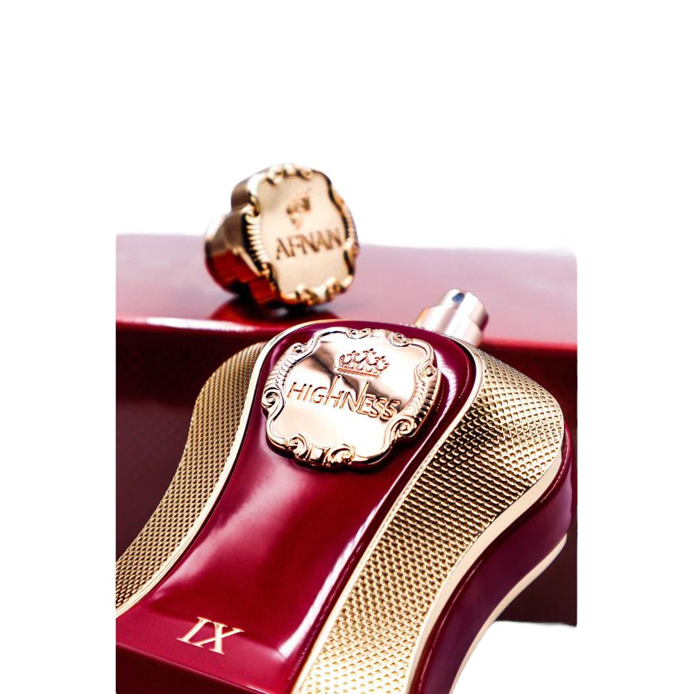 A close-up image of the luxurious "Highness Maroon IX" perfume bottle by Afnan Perfumes. The cap, embossed with the "AFNAN" logo, is detached and lies behind the bottle, highlighting the intricate design similar to a royal seal. The bottle itself is a rich maroon color with a rose gold textured finish and a label that features an embossed crown and the name "HIGHNESS" within a decorative border.