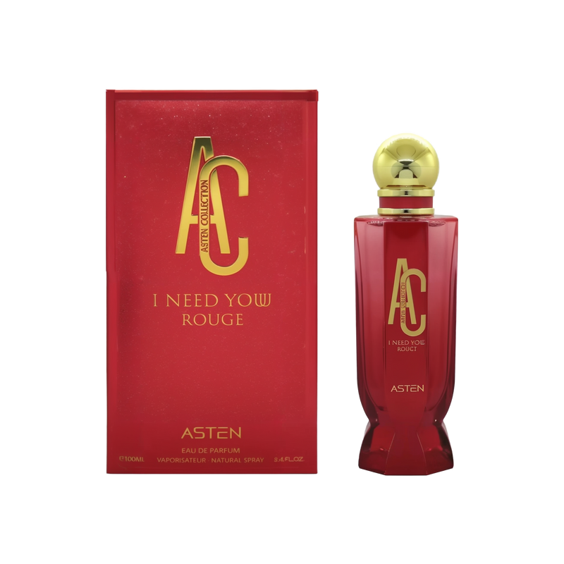 A deep-red rectangular box with gold “AC Asten Collection” and “I Need Yow Rouge” lettering stands beside a tall, matching red glass perfume bottle. The bottle features the same gold AC logo and text, topped by a round gold cap.