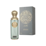 The image features a perfume bottle and its packaging from the "Gissah" Signature Collection, described as a light fragrance. The bottle is tall and cylindrical with a frosted light teal glass body, adorned with ornate gold medallions. It is capped with a gold, intricately designed spherical lid. Beside the bottle is the box, which is gray with a textured appearance and a large gold mandala-like design on the front, with the name "Gissah" printed at the top.