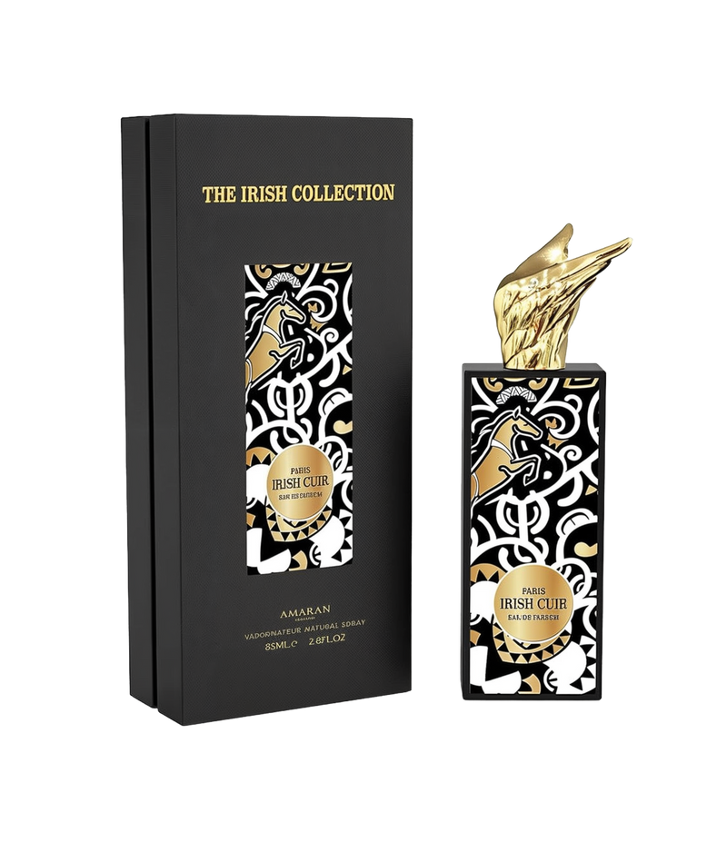 A tall rectangular black perfume bottle with bold black, white, and gold Celtic-inspired patterns, labeled “Irish Cuir” by Amaran, topped with a sculpted gold wing cap. It is shown alongside a matching black box labeled “The Irish Collection,” indicating an 85ml (2.8 fl oz) Eau De Parfum.