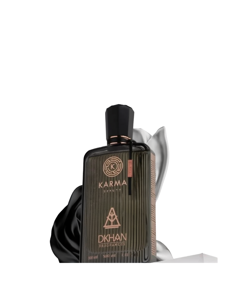 This image showcases a dark, elegantly textured perfume bottle for "Karma Beauty" by DKHAN Fragrances. The bottle appears to be made of ribbed glass with a luxurious matte finish and features the Karma Beauty logo embossed in a circular design at the top. Below the logo is the distinctive DKHAN Fragrances logo, resembling a heart within a diamond shape, set above the product details which indicate a 100ml quantity and 80% vol. The cap is a sleek black with a copper band.
