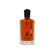 The image shows a rectangular glass perfume bottle with a black cap, filled with an orange-colored liquid. The bottle has several labels: the top one includes a circular logo with the text "KEHL" and a smaller text below it reads "INTENSE". In the center, there's a large stylized emblem with the text "DKHAN FRAGRANCES" beneath it.