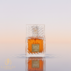 Lattafa Khamrah perfume in a faceted crystal bottle with orange liquid, reflected in water ripples.