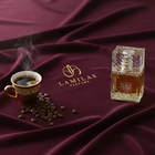 Lattafa Khamrah Qahwa perfume bottle beside steaming coffee cup on burgundy fabric.