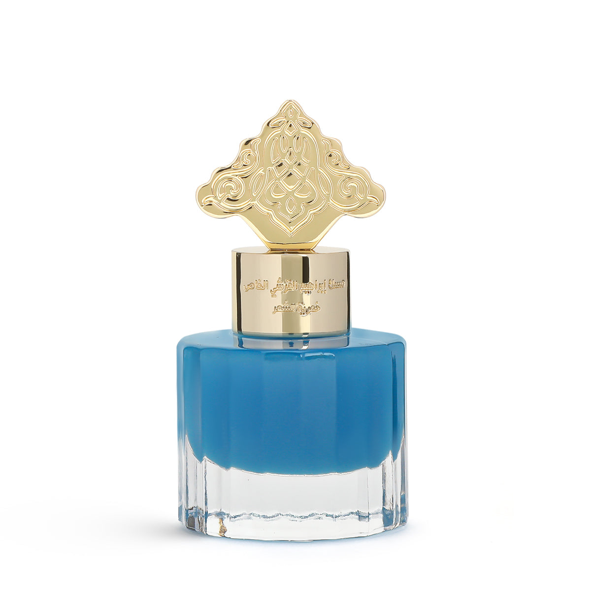 This image features a square-shaped perfume bottle with a blue gradient color, transitioning from a darker blue at the top to clear at the bottom. The cap is gold with intricate, ornate patterns resembling traditional Arabic designs. Arabic script is present on the gold band just below the cap, likely denoting the brand or fragrance name.