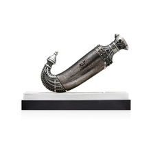 Decorative silver Khanjar dagger with ornate detailing displayed on a black and white stand
