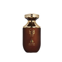  The image displays a perfume bottle labeled "Khashab Al Oud" by Bait Al Bakhoor. The bottle has a distinctive, rounded shape with a broad base that tapers slightly towards the top. It has a dark brown to black gradient color, symbolizing a woody essence, and is adorned with gold accents and Arabic calligraphy that accentuates its luxurious appeal. The perfume is noted to be an eau de parfum, with a volume of 100 ml or 3.4 fl. oz.