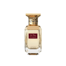 The image features a classic and elegant perfume bottle. The bottle is transparent with a multifaceted design that reflects light, giving it a luxurious crystal appearance. It has a broad, golden cap with decorative elements around its neck. On the front of the bottle, there is a maroon label with the text "La Fleur bouquet" in white cursive script, and below on the bottle's base is the brand name "AFNAN" in capital letters. 