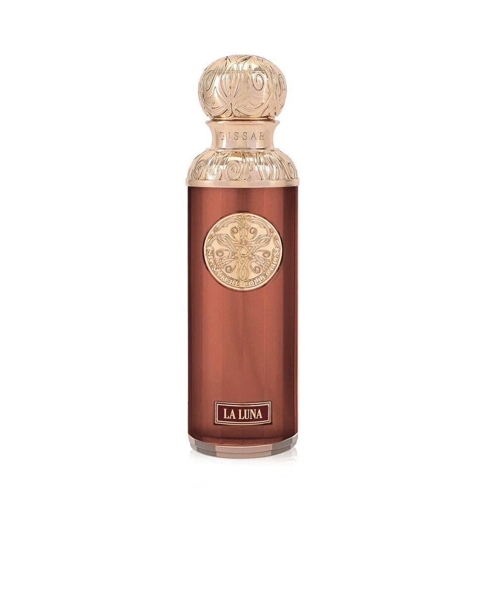 The image shows a perfume bottle named "La Luna" from the Gissah Signature Collection. The bottle is a glossy copper color with a cylindrical shape, and it features a decorative gold medallion in the center. The cap is a matching gold color with an ornate, embossed design, and the name "Gissah" is inscribed just below the neck of the bottle. At the bottom of the bottle, the name "LA LUNA" is displayed on a gold plaque, indicating the fragrance's name.
