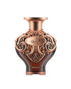 A high-resolution product shot of Le Falcone Niche Collection’s “Turath Intense” perfume bottle against a white background. The bottle has a dark amber, heart-shaped glass body topped with a wide, copper-toned neck and cap. Its upper half is covered in ornate, scrolling filigree in a polished copper finish, forming elegant arabesque patterns. A matching copper plaque at the front bears Arabic calligraphy above the word “TURATH,” and “INTENSE” appears in gold lettering near the base.