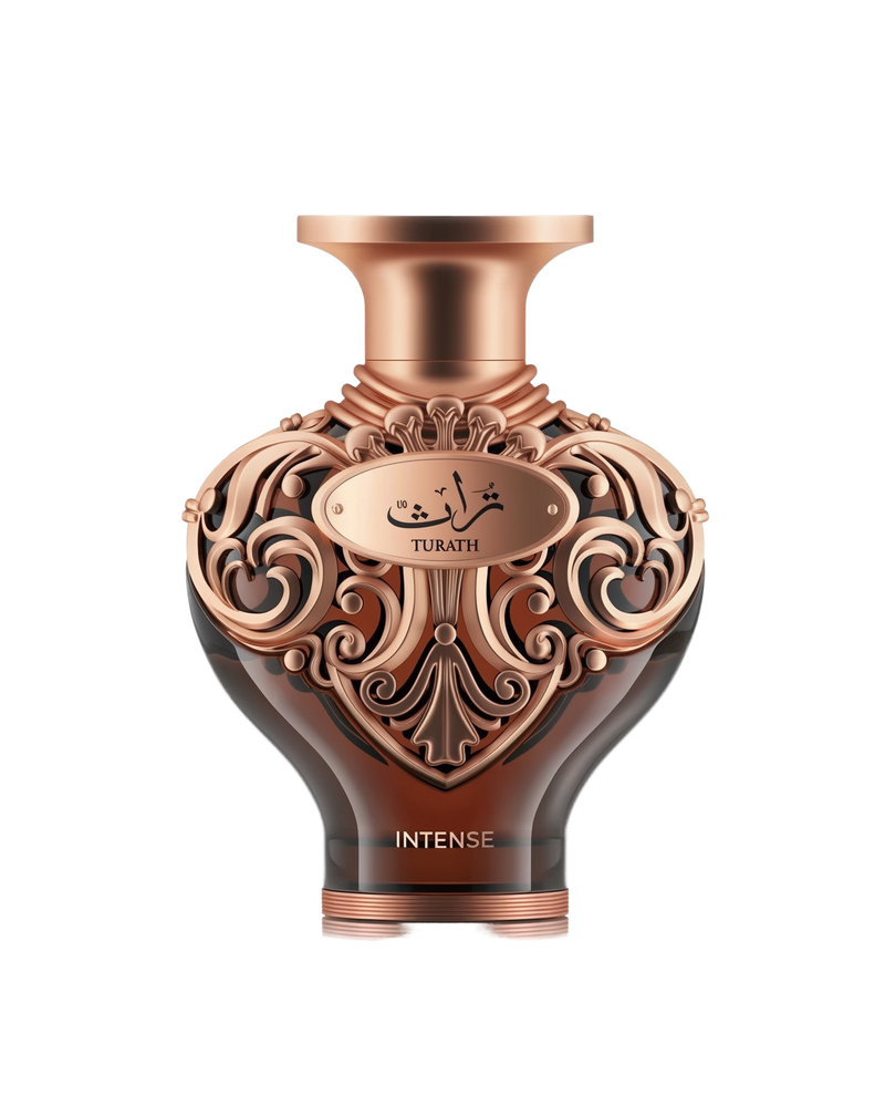 A high-resolution product shot of Le Falcone Niche Collection’s “Turath Intense” perfume bottle against a white background. The bottle has a dark amber, heart-shaped glass body topped with a wide, copper-toned neck and cap. Its upper half is covered in ornate, scrolling filigree in a polished copper finish, forming elegant arabesque patterns. A matching copper plaque at the front bears Arabic calligraphy above the word “TURATH,” and “INTENSE” appears in gold lettering near the base.