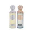The image features two perfume bottles from the Gissah collection, "Hudson II" and "Imperial II." Both bottles have tall, cylindrical shapes with ornate silver caps featuring embossed designs. "Hudson II" has a light yellow tinted glass body with a silver medallion, and "Imperial II" has a light blue tinted glass body with a copper medallion. Each bottle is labeled with its respective name in elegant font at the bottom. 