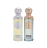 The image features two perfume bottles from the Gissah collection, "Hudson II" and "Imperial II." Both bottles have tall, cylindrical shapes with ornate silver caps featuring embossed designs. "Hudson II" has a light yellow tinted glass body with a silver medallion, and "Imperial II" has a light blue tinted glass body with a copper medallion. Each bottle is labeled with its respective name in elegant font at the bottom. 