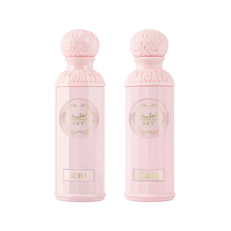 The image features two light pink perfume bottles from the "Legend of the Sky for Her" collection by Gissah, named "Sora" and "Ellora." The bottles have a cylindrical shape with detailed ornamental designs embossed on the silver caps and the central gold medallions. The names "Sora" and "Ellora" are inscribed on gold plaques at the base of each bottle. 